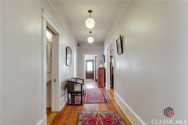 corridor with light wood finished floors and baseboards