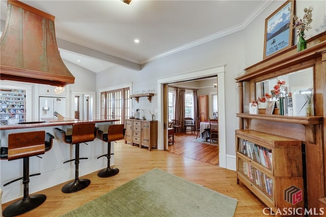 kitchen with light wood-style flooring, lofted ceiling, french doors, crown molding, and white fridge with ice dispenser