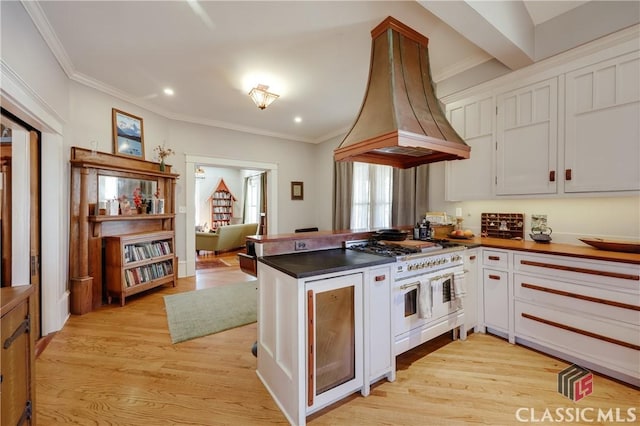 kitchen with custom exhaust hood, a peninsula, double oven range, light wood finished floors, and crown molding