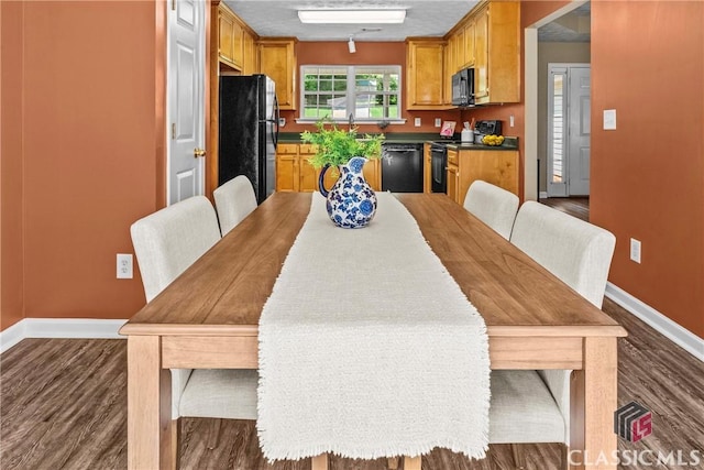 dining space featuring dark wood finished floors and baseboards