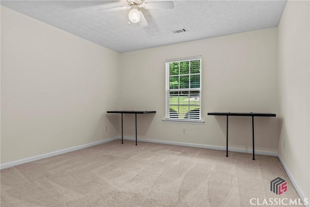 carpeted spare room with a ceiling fan, a textured ceiling, and baseboards