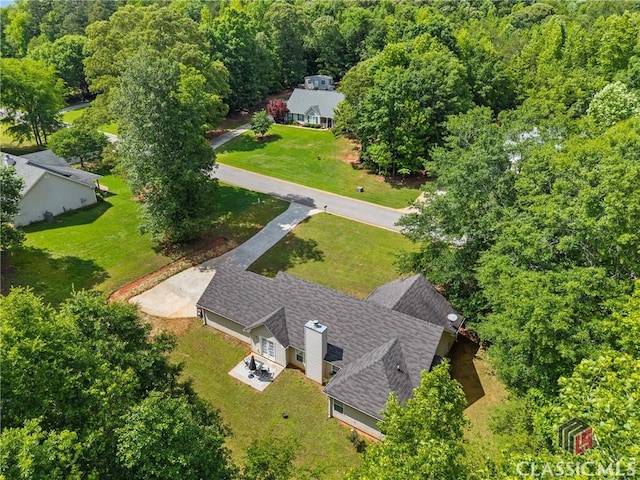aerial view of property and surrounding area with a heavily wooded area