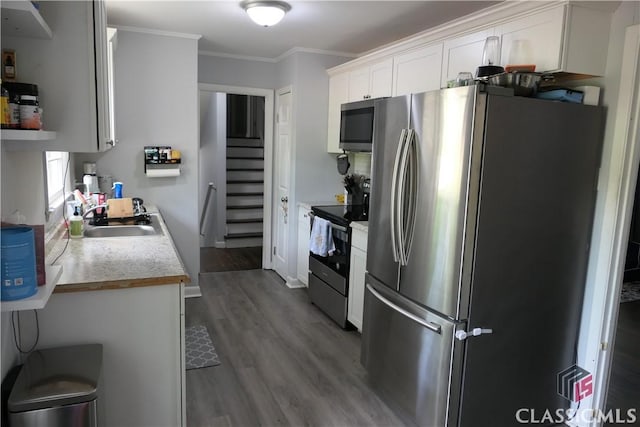 348 Jefferson River Rd, Athens, GA 30607 - kitchen with appliances with stainless steel finishes, a sink, wood finished floors, ornamental molding, and white cabinets