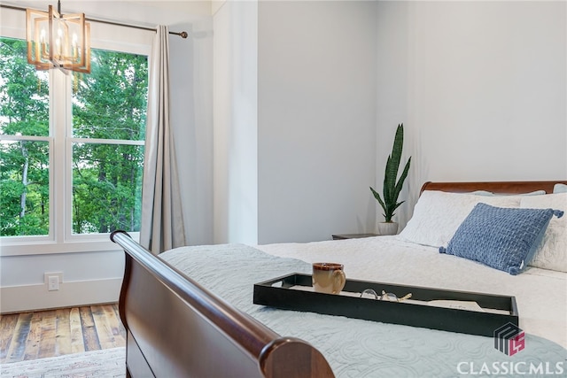 bedroom featuring a chandelier and wood finished floors
