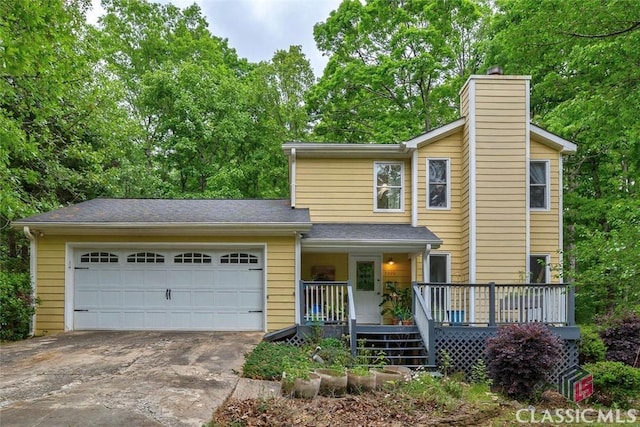 view of front of property featuring covered porch, driveway, a garage, and a chimney