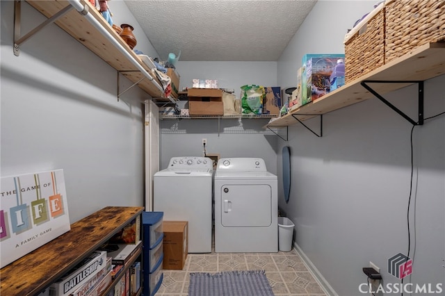 washroom featuring washing machine and dryer, a textured ceiling, and baseboards