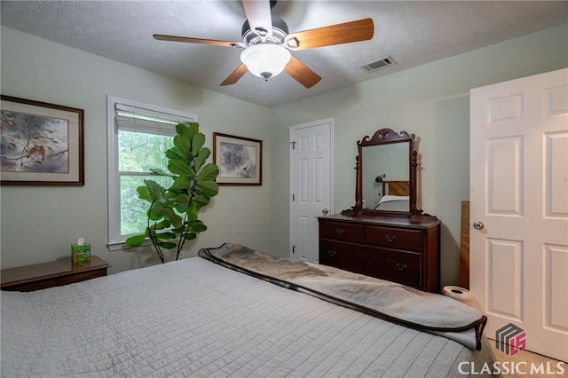 bedroom featuring a ceiling fan and a textured ceiling