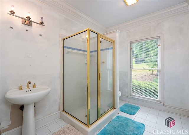 bathroom with tile patterned floors, crown molding, a stall shower, toilet, and baseboards