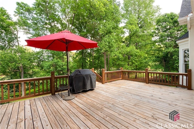 wooden deck with grilling area and view of wooded area