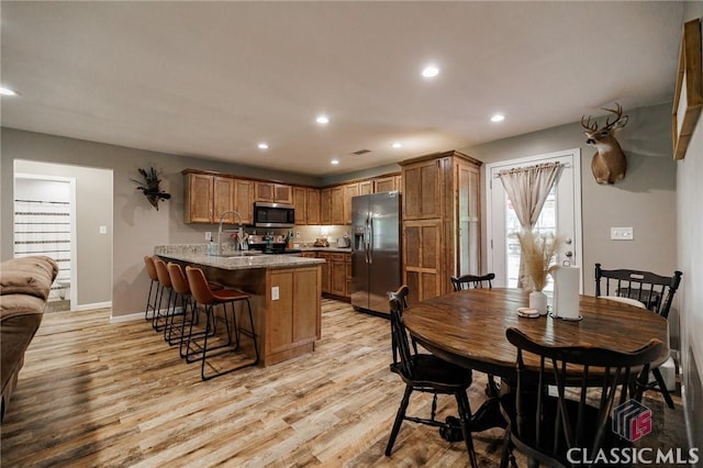 2100 New Hope Church Rd, Comer, GA 30629 - kitchen with stainless steel appliances, a peninsula, a breakfast bar, light wood-style floors, and recessed lighting