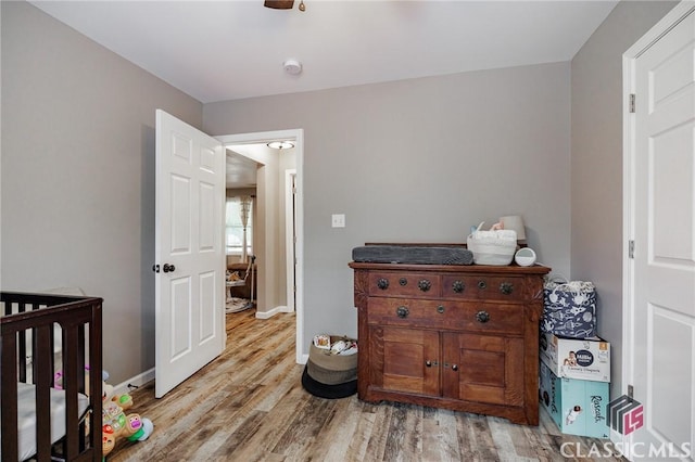 2100 New Hope Church Rd, Comer, GA 30629 - bedroom featuring wood finished floors, baseboards, and a crib