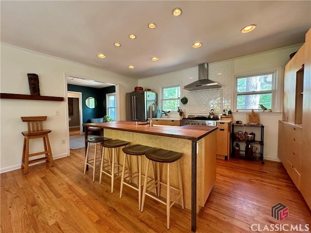 160 Gran Ellen Dr, Athens, GA 30606 - kitchen with wall chimney range hood, freestanding refrigerator, butcher block countertops, recessed lighting, and light wood-style flooring