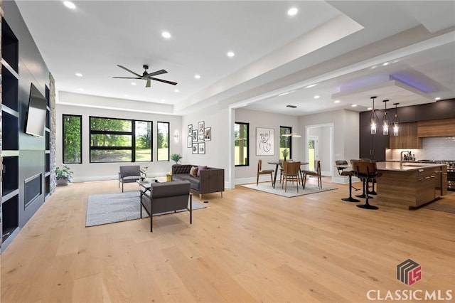 1895 Vintage Pl, Watkinsville, GA 30677 - living area featuring light wood finished floors, ceiling fan, recessed lighting, a fireplace, and a tray ceiling