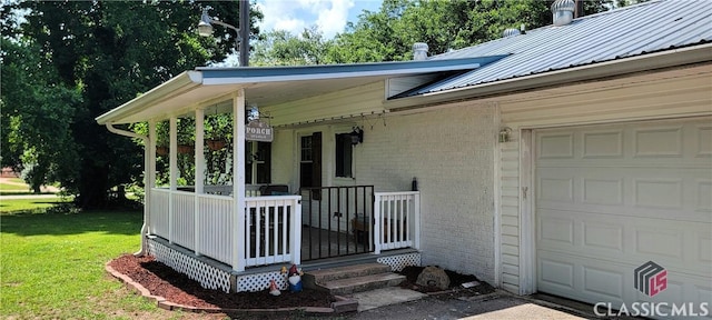 75 Gunnell Rd, Comer, GA 30629 - view of front of home with brick siding, a front lawn, a garage, metal roof, and a porch