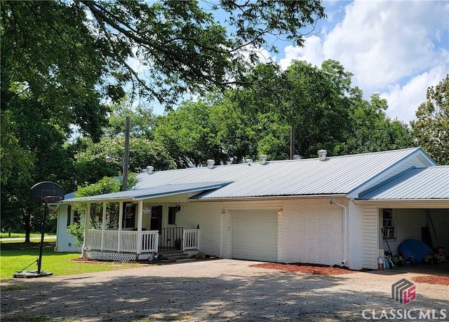 75 Gunnell Rd, Comer, GA 30629 - ranch-style home featuring covered porch, a garage, gravel driveway, metal roof, and brick siding