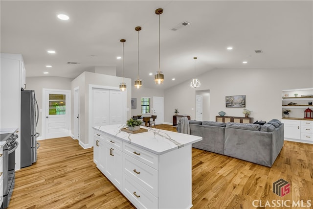 3920 Old Lexington Rd, Athens, GA 30605 - kitchen featuring stainless steel appliances, vaulted ceiling, light wood-type flooring, white cabinetry, and light stone countertops