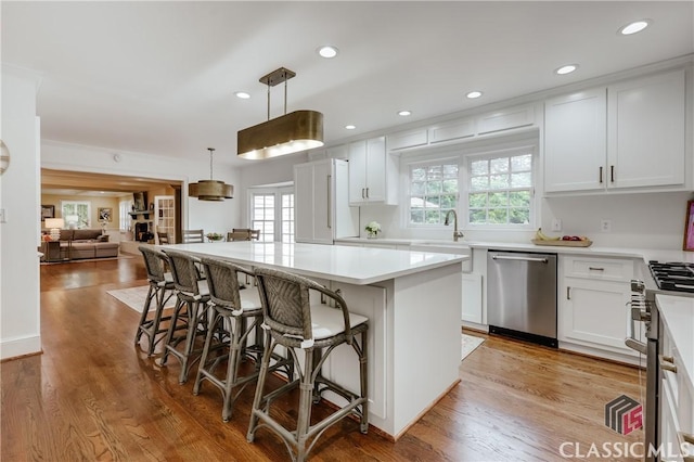 155 Wexford Pl, Athens, GA 30609 - kitchen featuring appliances with stainless steel finishes, a sink, a kitchen island, a breakfast bar, and white cabinets