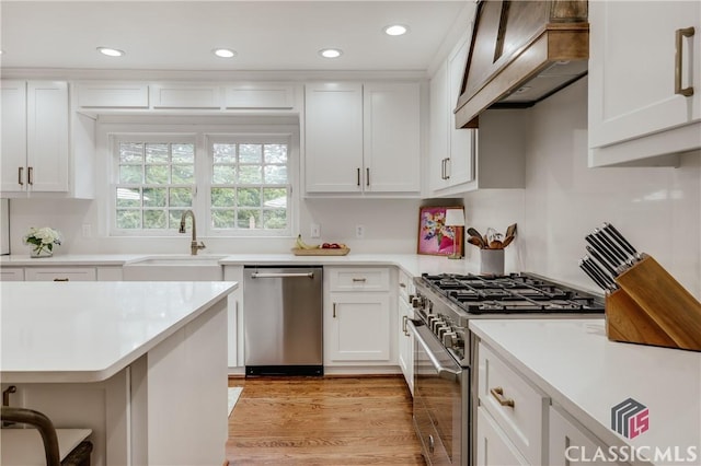 155 Wexford Pl, Athens, GA 30609 - kitchen with stainless steel appliances, custom range hood, a sink, light countertops, and recessed lighting
