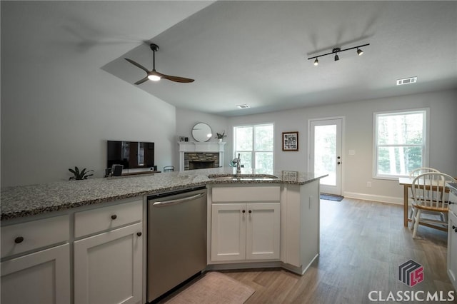 35 Westwood St, Danielsville, GA 30633 - kitchen with dishwasher, a sink, a ceiling fan, light wood-type flooring, and a stone fireplace