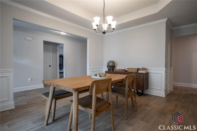 35 Westwood St, Danielsville, GA 30633 - dining area with a chandelier, wood finished floors, wainscoting, a raised ceiling, and a decorative wall