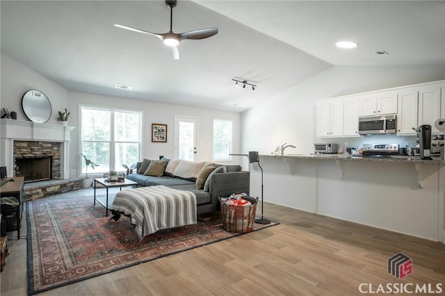 35 Westwood St, Danielsville, GA 30633 - living area featuring lofted ceiling, wood finished floors, ceiling fan, a fireplace, and track lighting