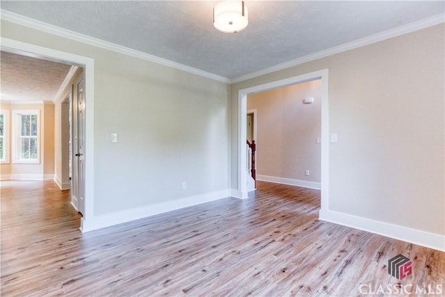 4085 Fawn Vly, Loganville, GA 30052 - spare room with wood finished floors, a textured ceiling, crown molding, and baseboards