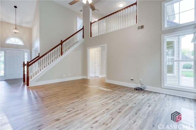 4085 Fawn Vly, Loganville, GA 30052 - unfurnished living room featuring high vaulted ceiling, light wood-style floors, stairs, baseboards, and ceiling fan