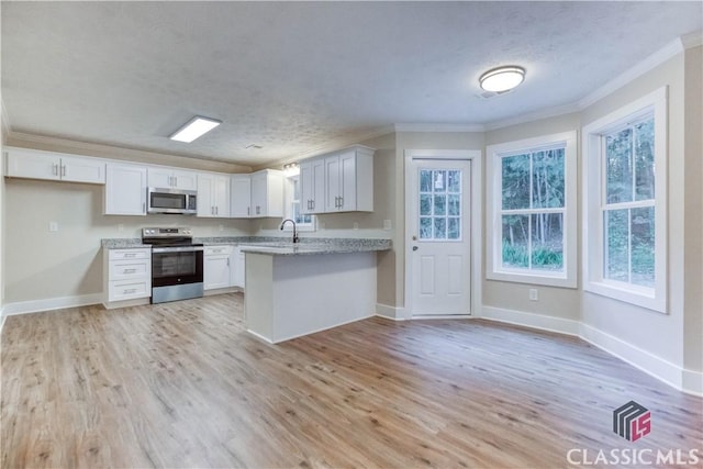 4085 Fawn Vly, Loganville, GA 30052 - kitchen featuring stainless steel appliances, ornamental molding, light wood finished floors, a sink, and a peninsula