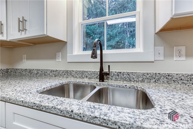 4085 Fawn Vly, Loganville, GA 30052 - kitchen view of a sink, white cabinets, and light stone countertops