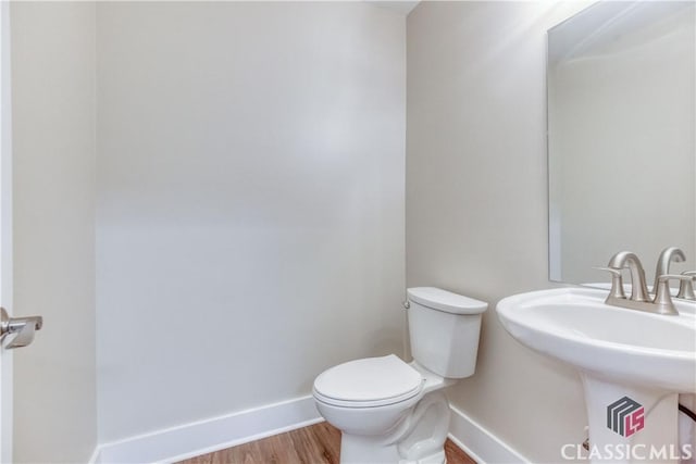 4085 Fawn Vly, Loganville, GA 30052 - half bath with baseboards, toilet, wood finished floors, and a sink