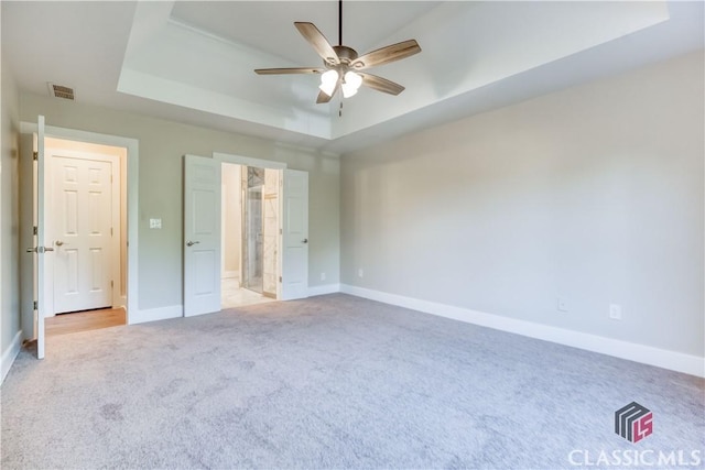 4085 Fawn Vly, Loganville, GA 30052 - unfurnished bedroom featuring a tray ceiling, light colored carpet, baseboards, and ensuite bath