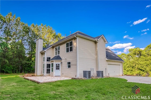 4085 Fawn Vly, Loganville, GA 30052 - back of property featuring concrete driveway, a chimney, a yard, and cooling unit