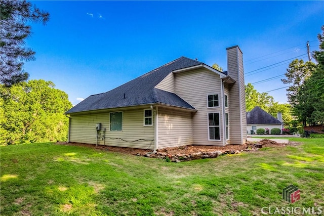4085 Fawn Vly, Loganville, GA 30052 - rear view of house featuring a chimney, a lawn, and a shingled roof