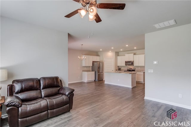 334 Pepin Ct, Hoschton, GA 30548 - living room featuring a ceiling fan, a chandelier, wood finished floors, recessed lighting, and baseboards