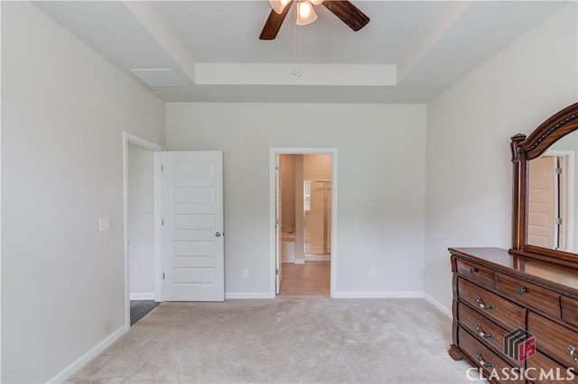 334 Pepin Ct, Hoschton, GA 30548 - unfurnished bedroom featuring a tray ceiling, light colored carpet, baseboards, ensuite bath, and a ceiling fan