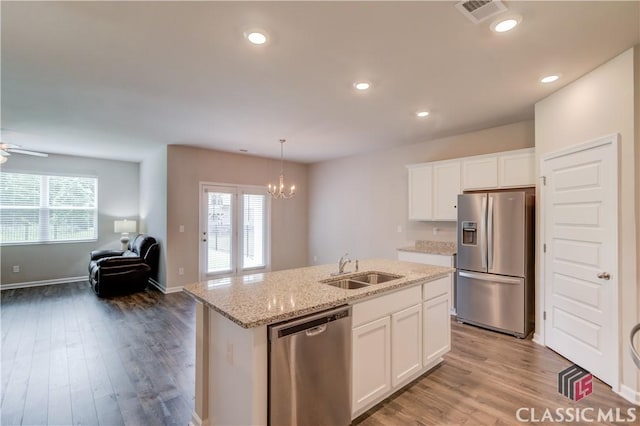 334 Pepin Ct, Hoschton, GA 30548 - kitchen with appliances with stainless steel finishes, a sink, open floor plan, a chandelier, and white cabinetry