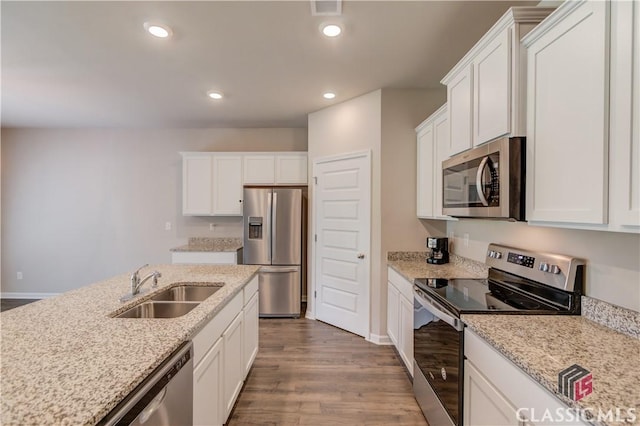 334 Pepin Ct, Hoschton, GA 30548 - kitchen with appliances with stainless steel finishes, wood finished floors, white cabinetry, a sink, and recessed lighting