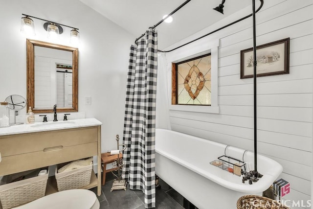 99 Hickory St, Commerce, GA 30529 - full bath featuring a soaking tub, vanity, toilet, a shower with shower curtain, and wooden walls
