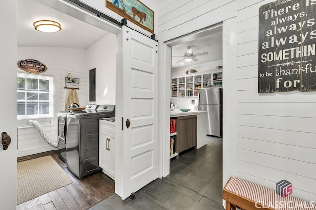 99 Hickory St, Commerce, GA 30529 - laundry room with a barn door, a ceiling fan, cabinet space, wooden walls, and independent washer and dryer