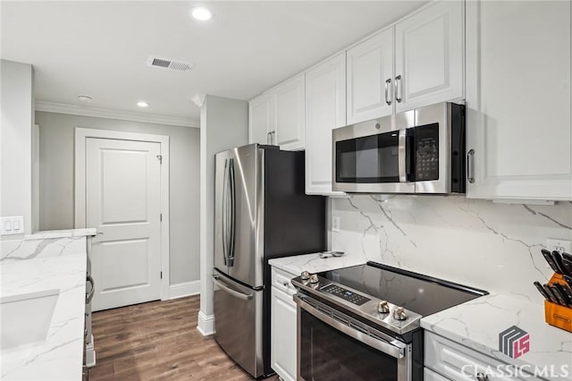 1050 Tailwater Unit A, Greensboro, GA 30642 - kitchen with appliances with stainless steel finishes, white cabinets, ornamental molding, decorative backsplash, and light stone counters