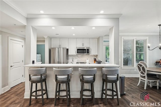 1050 Tailwater Unit A, Greensboro, GA 30642 - kitchen featuring stainless steel appliances, white cabinetry, tasteful backsplash, recessed lighting, and a kitchen bar