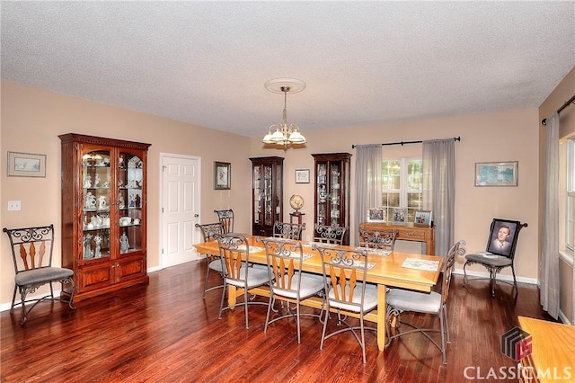 224 Red Oak Dr, Maysville, GA 30558 - dining room with dark wood-type flooring, a chandelier, a textured ceiling, and baseboards