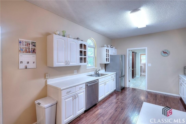 224 Red Oak Dr, Maysville, GA 30558 - kitchen with appliances with stainless steel finishes, glass insert cabinets, white cabinetry, a textured ceiling, and a sink