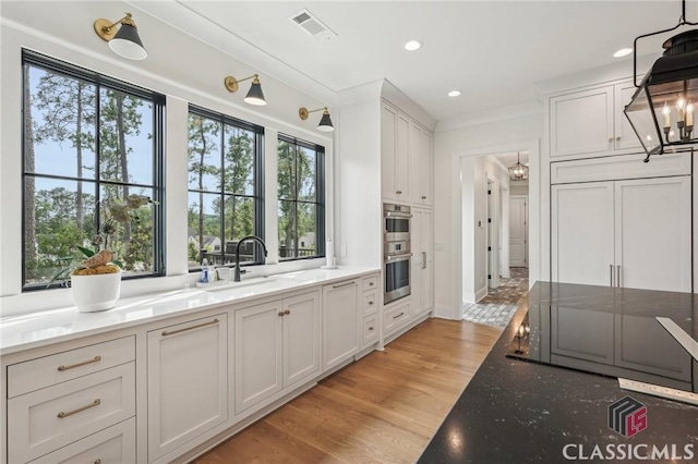 1170 Broadpoint Dr, Greensboro, GA 30642 - kitchen with double oven, plenty of natural light, a sink, a chandelier, and recessed lighting