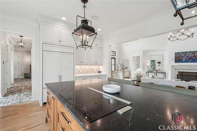 1170 Broadpoint Dr, Greensboro, GA 30642 - kitchen with a chandelier, crown molding, black electric stovetop, open floor plan, and recessed lighting