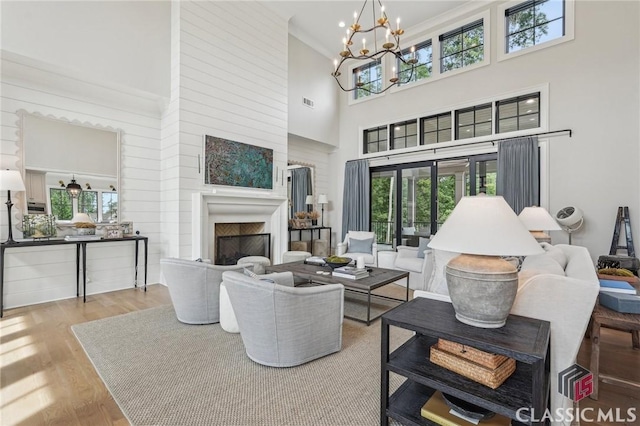 1170 Broadpoint Dr, Greensboro, GA 30642 - living area with a chandelier, a high ceiling, healthy amount of natural light, and a fireplace
