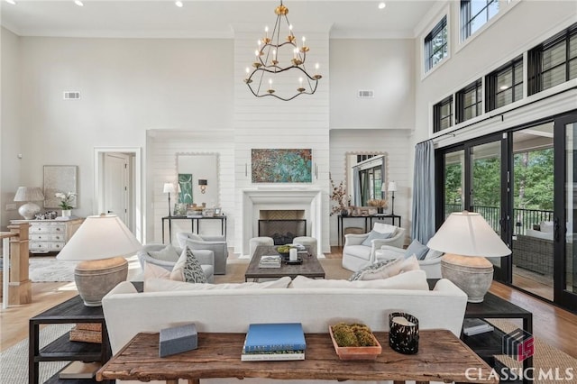 1170 Broadpoint Dr, Greensboro, GA 30642 - living area with a high ceiling, wood finished floors, a chandelier, recessed lighting, and a fireplace