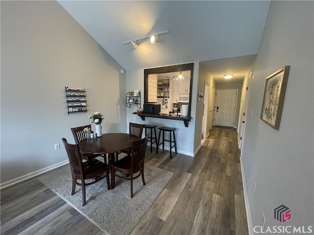 2165 Milledge Dr S, Athens, GA 30605 - dining area featuring vaulted ceiling, rail lighting, dark wood-style floors, and baseboards