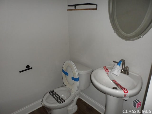 628 Holliman Cir, Pendergrass, GA 30567 - half bathroom with toilet, baseboards, wood finished floors, and a sink