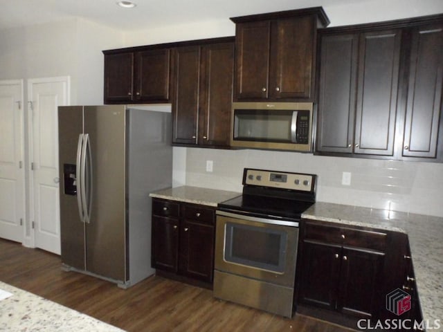 628 Holliman Cir, Pendergrass, GA 30567 - kitchen featuring appliances with stainless steel finishes, dark wood finished floors, tasteful backsplash, and light stone counters